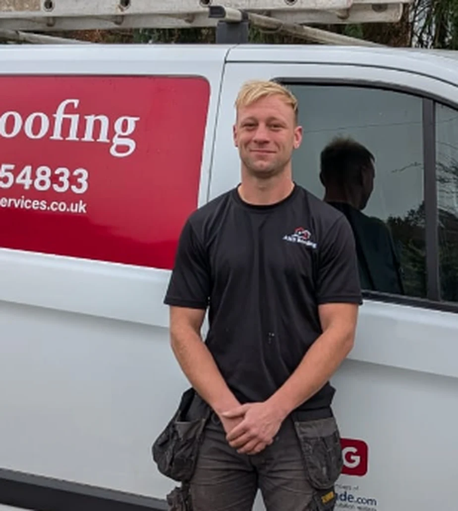 Adam Bull, owner of AMB Roofing Services, in front of the company van