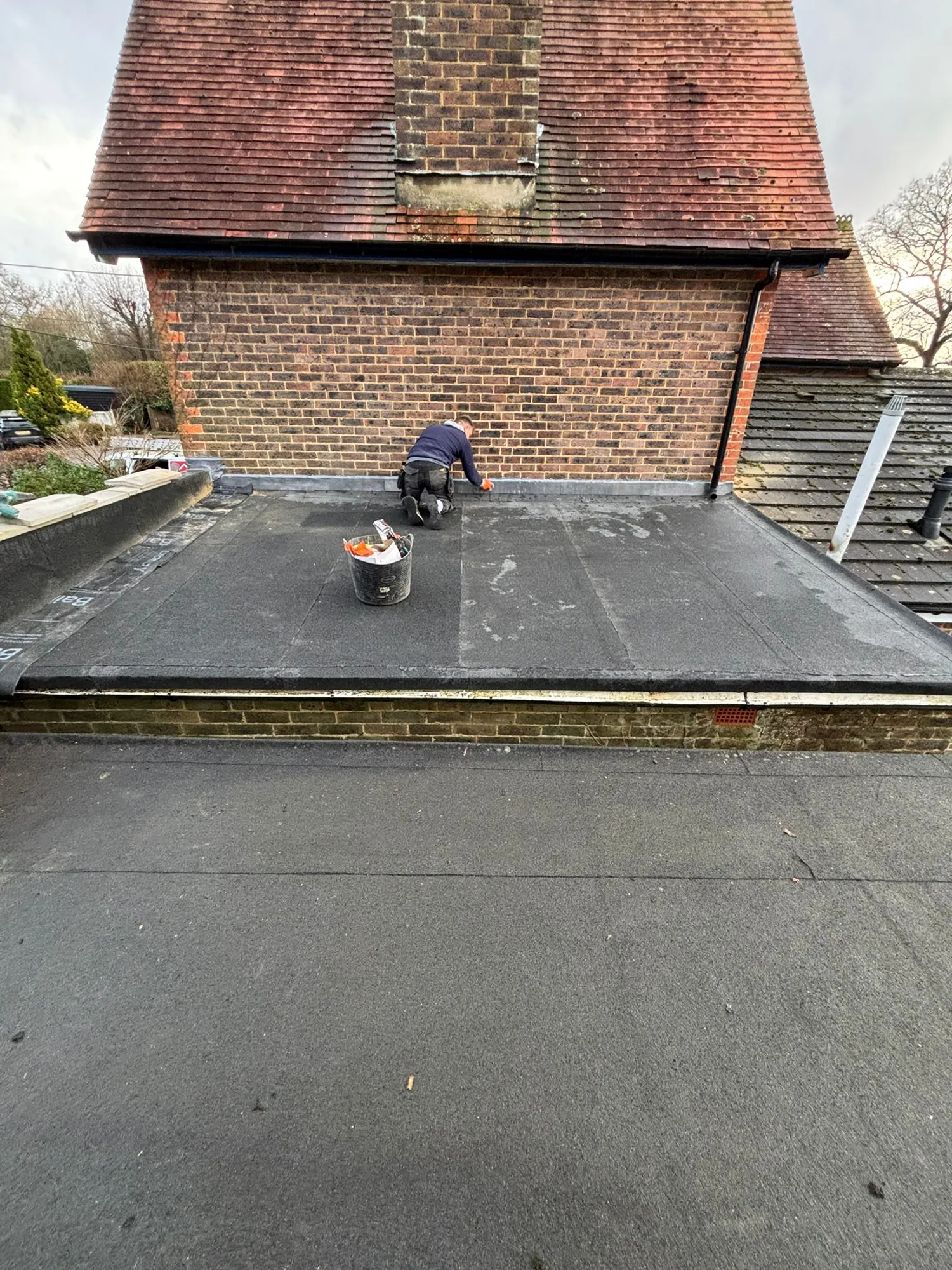 New felt flat roof being laid and dressed